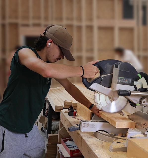 Young man using miter saw